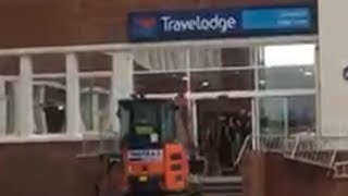 Extended video outside view Mini digger wrecks travelodge hotel because they didnt get paid [upl. by Ahsial]